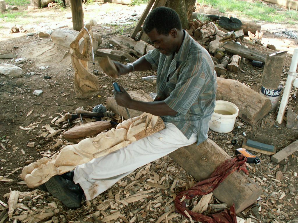 SWAZILAND - een man bezig met hout bewerken