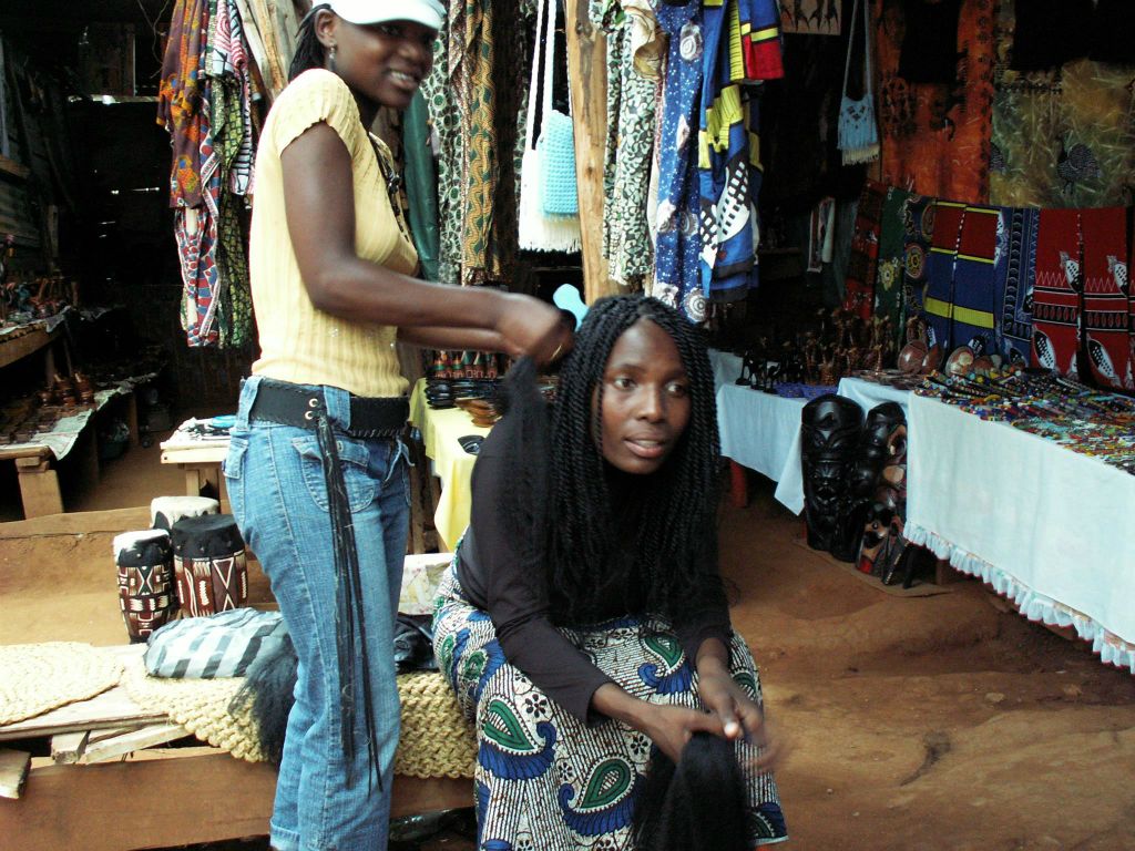 SWAZILAND - een vrouw krijgt hair extensions