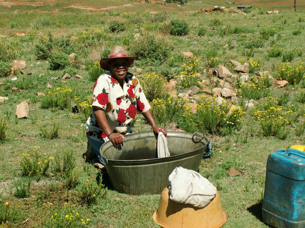 LESOTHO - een vrouw die de was aan het doen is in een dorp
