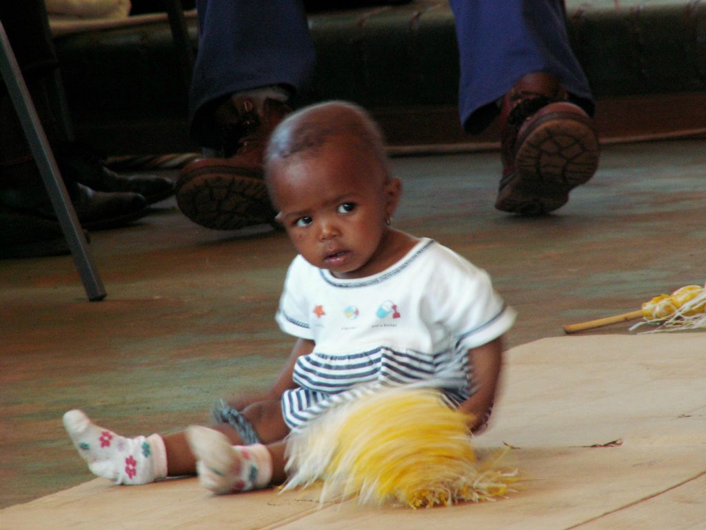 LESOTHO - een kind bij het optreden in het gemeenschaphuis van een dorp