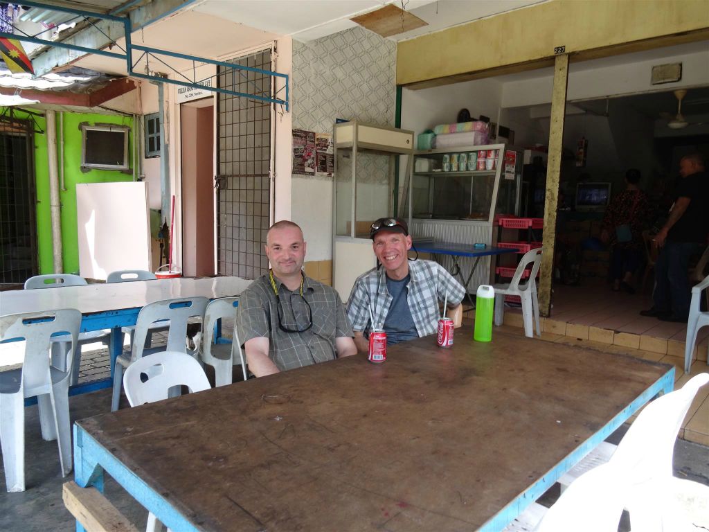 SERIAN - Kees en Carlos drinken een cola bij het Wak Badul cafe