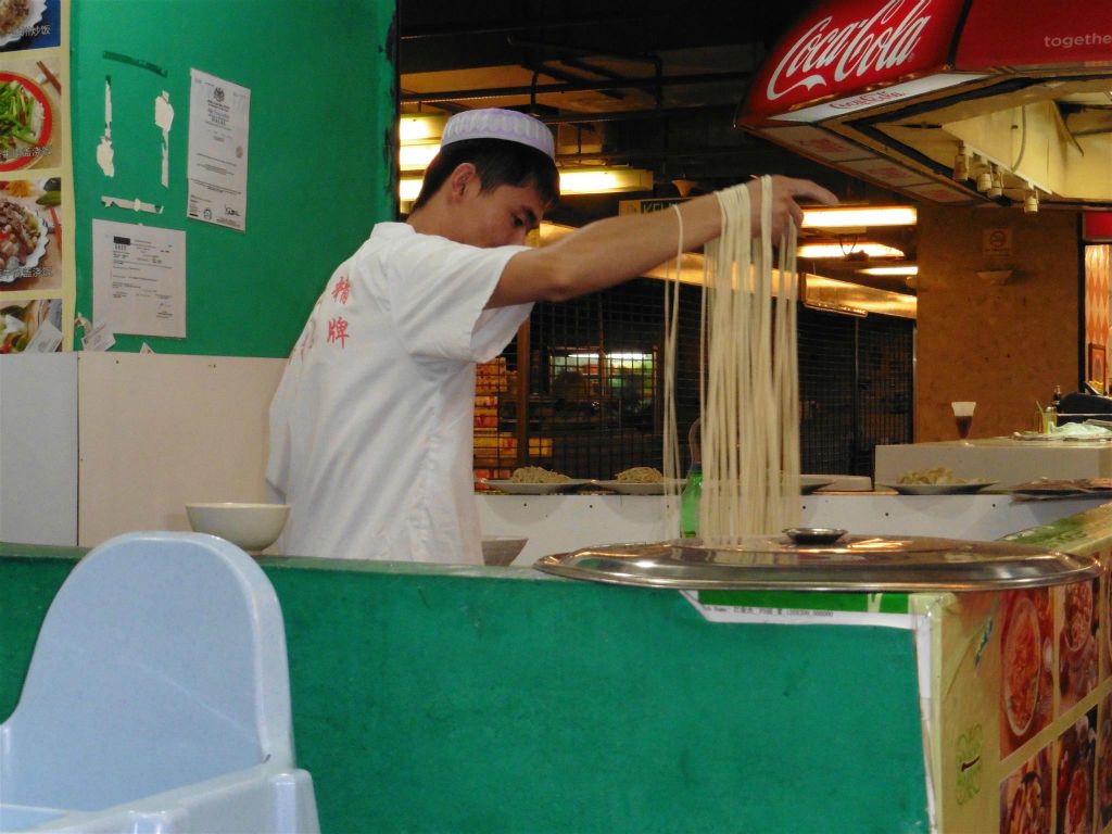 KOTA KINABALU - de kok die noodles aan het maken is in het Chinese Muslim Food restaurant waar Kees en Carlos gegeten hebben