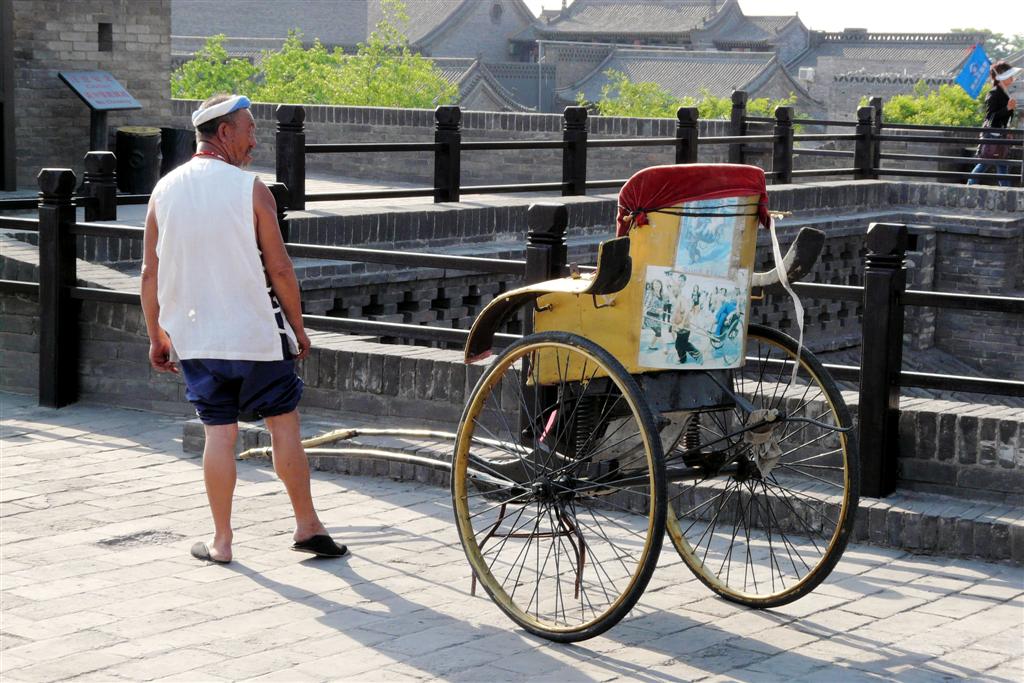 PINGYAO - Chinees met riksja op de stadsmuur van het oude centrum