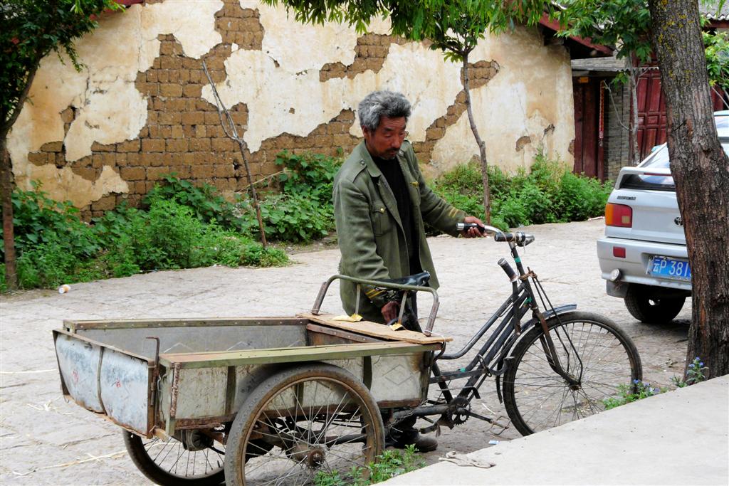 LIJIANG - een man met bakfiets in het dorp Baisha