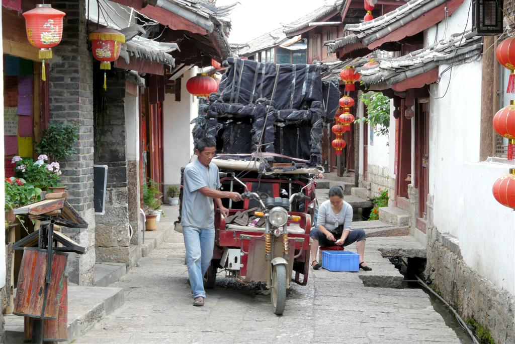 LIJIANG - spullen vervoer op een brommer in het oude centrum