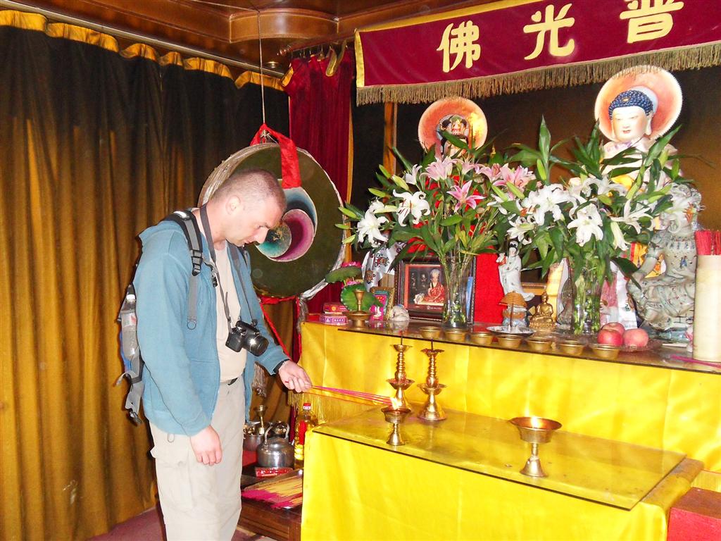 LIJIANG - Carlos steekt wierookstokjes aan in een tempel in het Black Dragon Pool Park