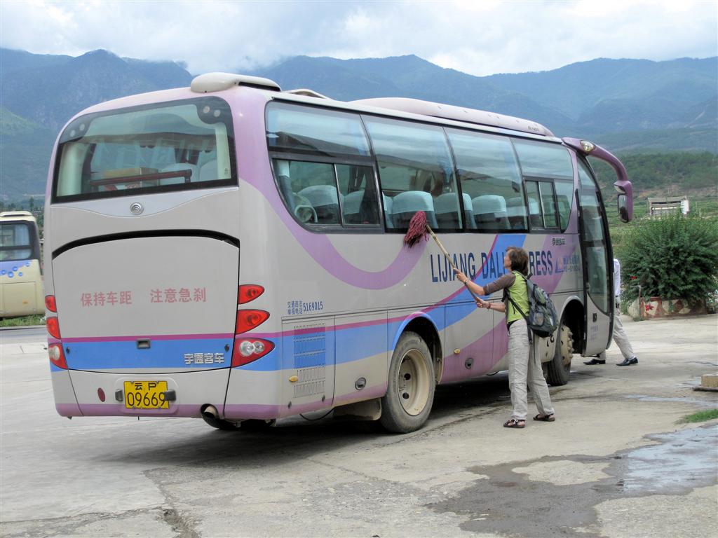 LIJIANG -> DALI - onze reisbegeleidster Trudy en chauffeur wassen de ramen van de bus