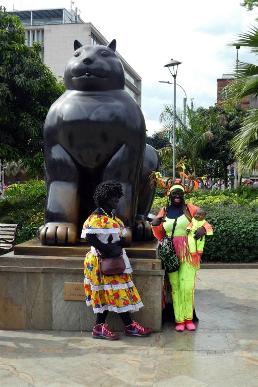 MEDELLIN - twee mensen verkleed als zwarte piet bij een standbeeld op het Botero plein gemaakt door kunstenaar, schilder en beeldhouwer Fernando Botero