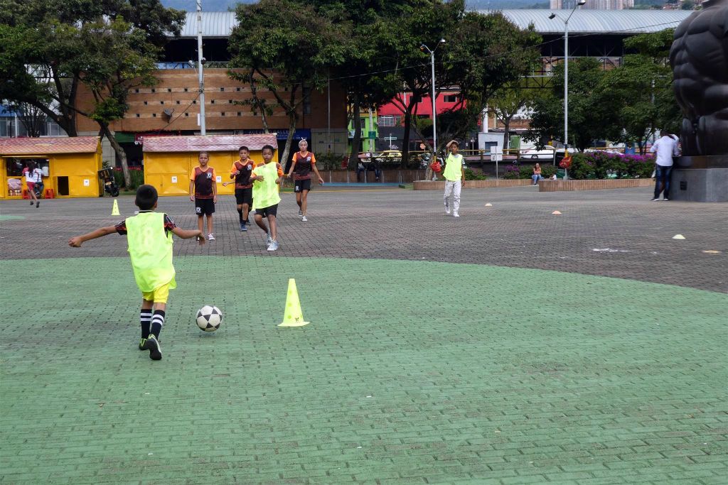 MEDELLIN - enkele straatkinderen aan het voetballen op het San Antonio plein