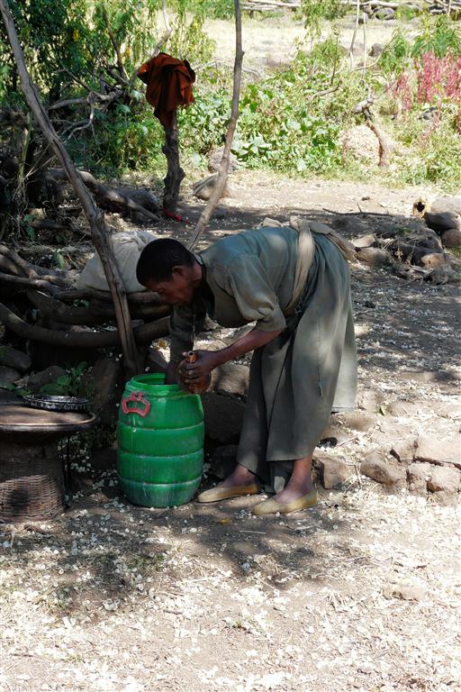 BAHIR DAR -> GONDAR - een Ethiopische vrouw haalt de mix voor de injera uit een ton