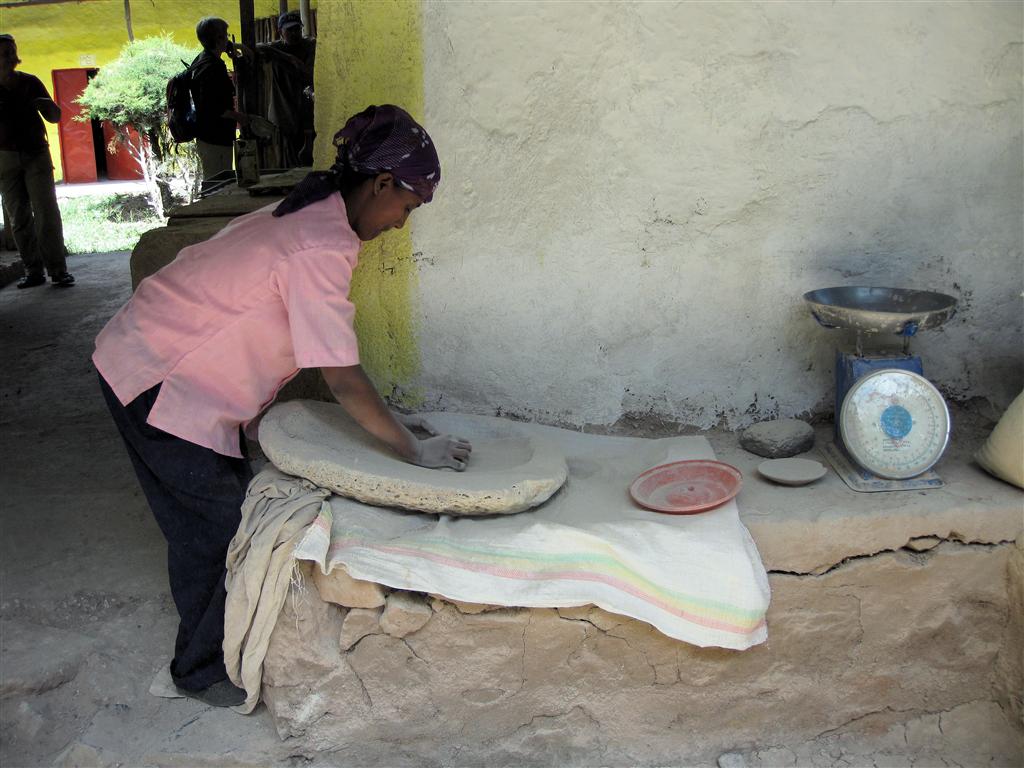 GONDAR -> DEBARK - het schuren van steen om grondstof voor klei te maken bij het Ploughshare women's craft training center
