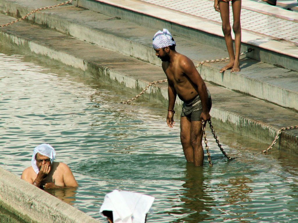 INDIA - DELHI - twee mannen aan het badderen het bad bij de Sinh tempel