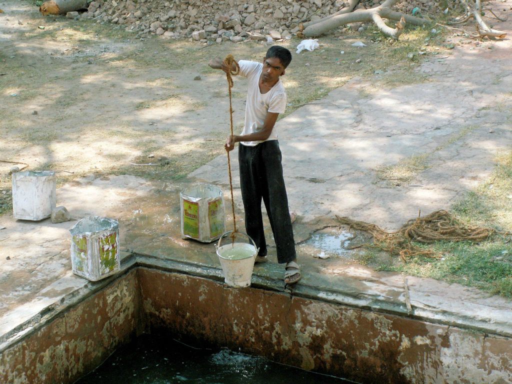 INDIA - JAIPUR - een man die water haalt bij de Royal Gaitor (Cenotaphs of Gatore)