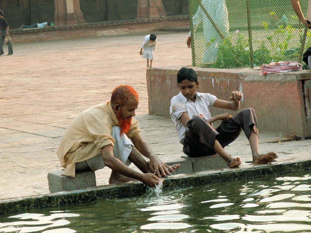 INDIA - SIKRI - eeen man die zijn voeten aan het wassen is bij de Jama Mashid moskee bij de Fatehpur Sikri