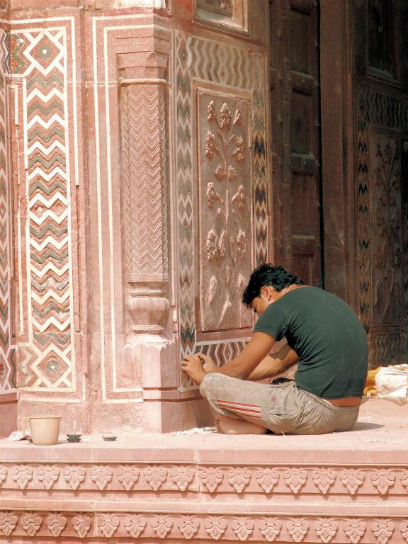 INDIA - AGRA - een man aan het werk bij een moskee bij de Taj Mahal