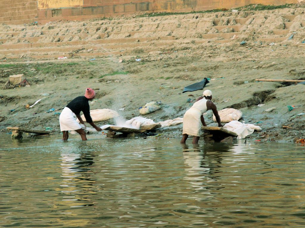 INDIA - VARANASI - twee mensen wassen lakens bij de Ganges rivier