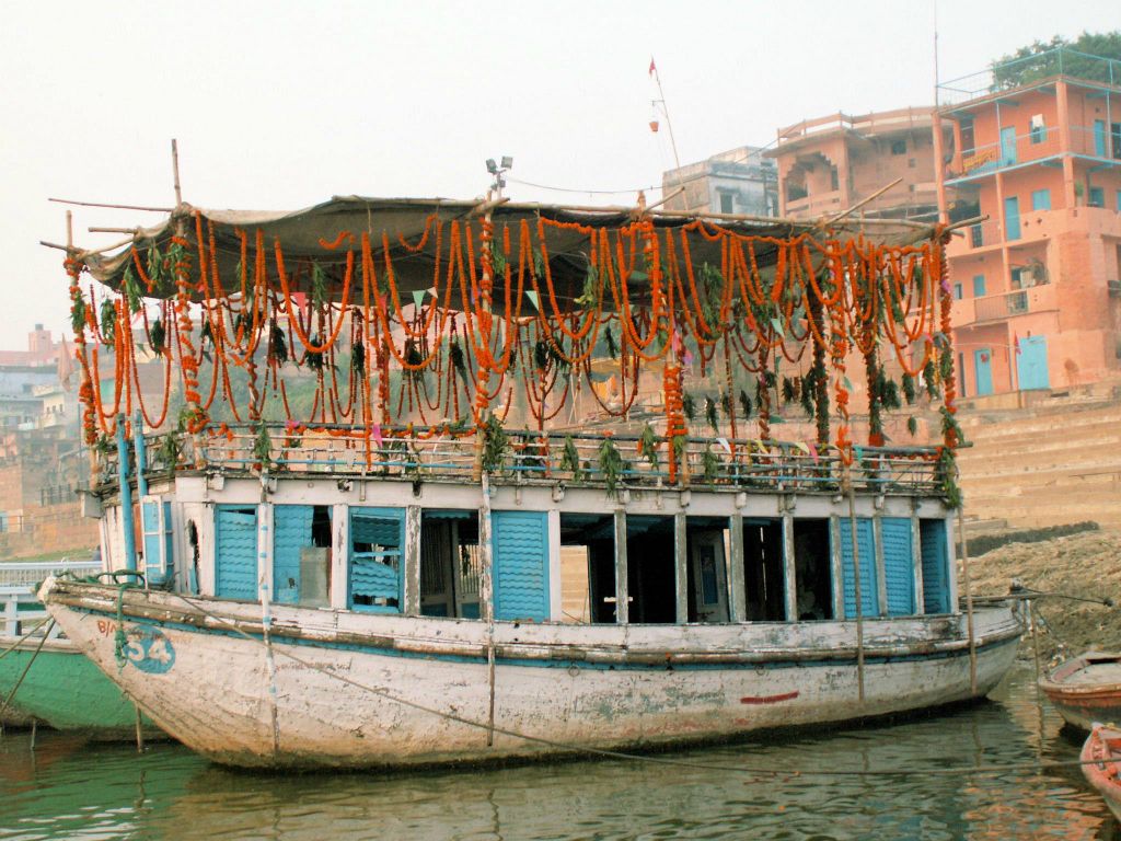 INDIA - VARANASI - een versierde boot bij de Ganges rivier