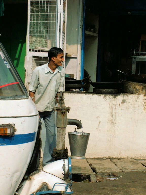 INDIA - VARANASI - een man die water aan het halen is