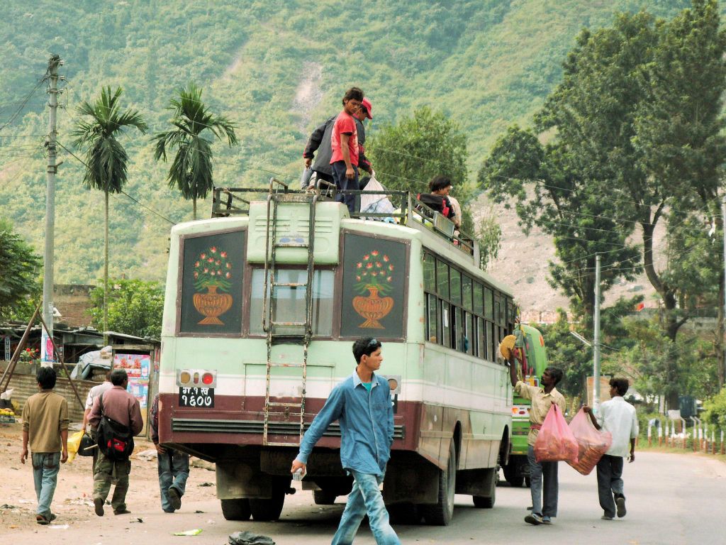 NEPAL - POKHARA -> KATHMANDU - verschillende mannen proberen hun etenswaar te slijten bij een lokale Nepalese bus