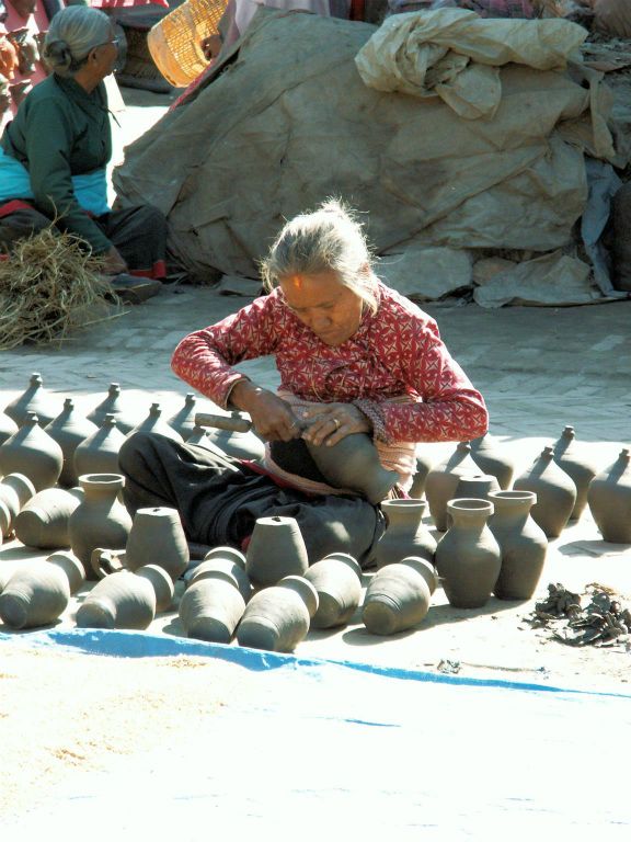 NEPAL - KATHMANDU (BHAKTAPUR) - een oude vrouw bezig met maken vazen bij Potter's Square