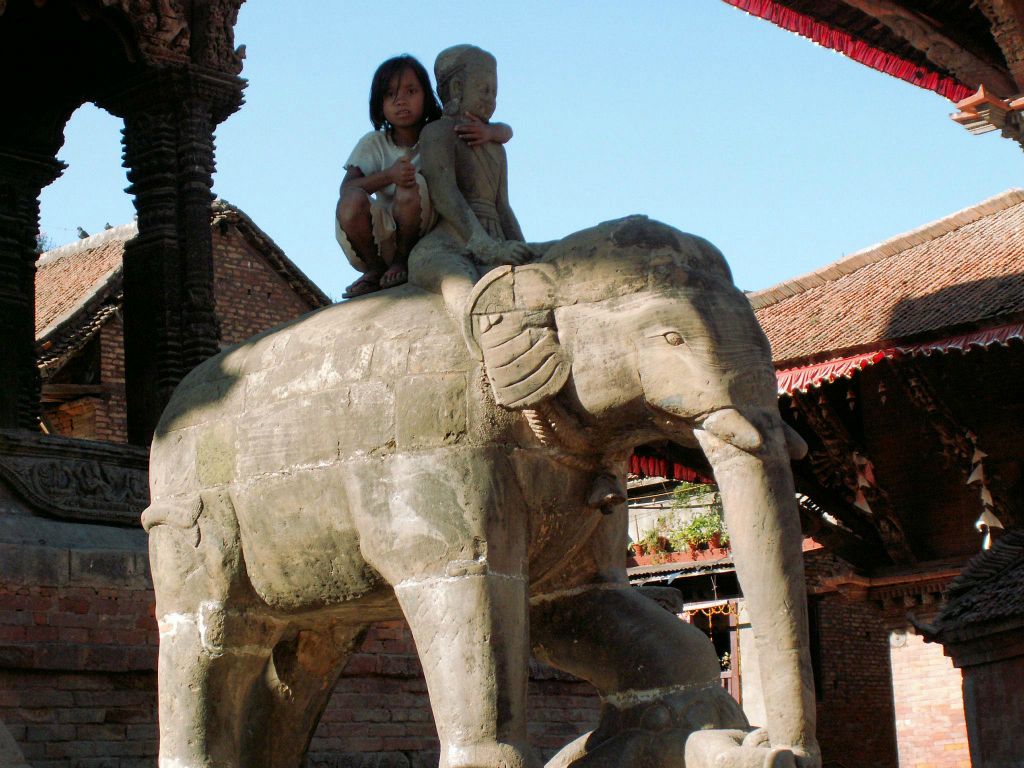 NEPAL - KATHMANDU (PATAN) - een kind op een beeld bij de Vishwanath tempel op Patan Durbar Squara