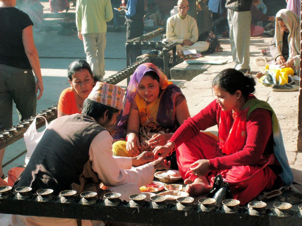 NEPAL - KATHMANDU (PATAN) - drie vrouwen bij een levenslot verteller