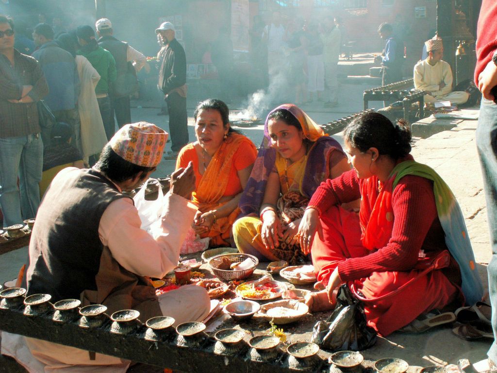 NEPAL - KATHMANDU (PATAN) - drie vrouwen bij een levenslot verteller