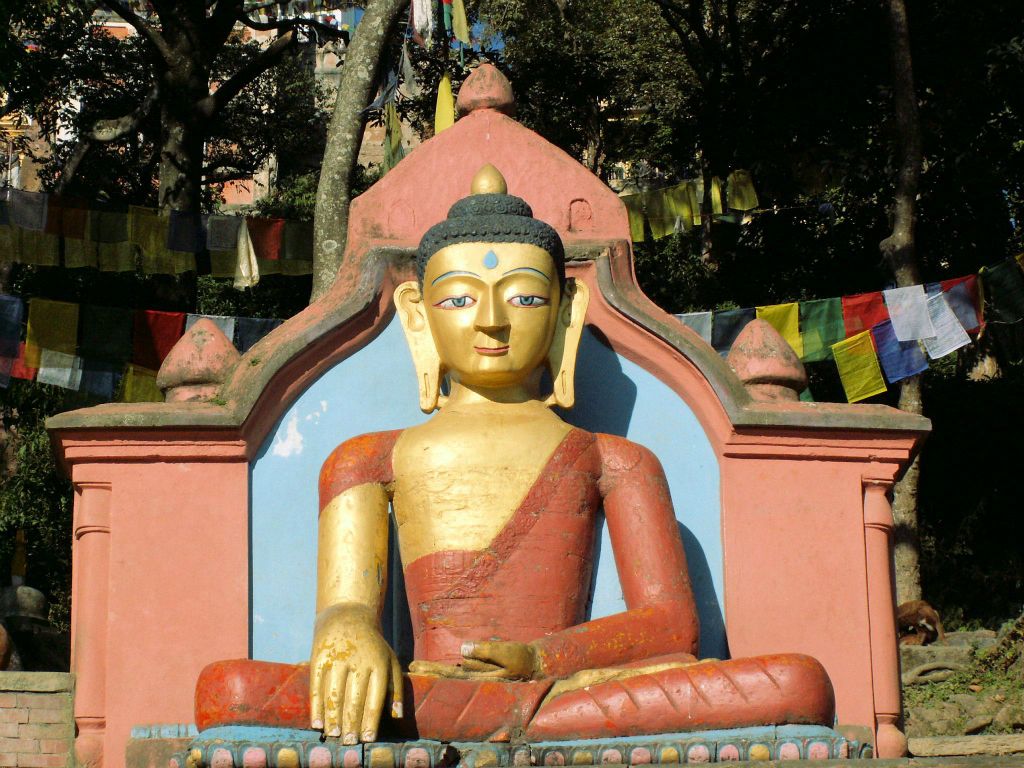 NEPAL - KATHMANDU - een boeddha beeld bij de ingang van de Swayambhunath stoepa