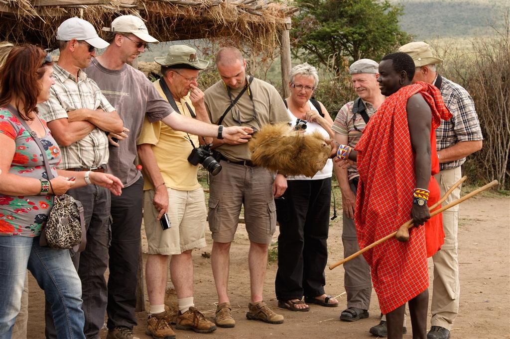 KENIA - NAIVASHA -> MASAI MARA NATIONAL PARK - een Masai laat een stuk huid van een leeuw zien