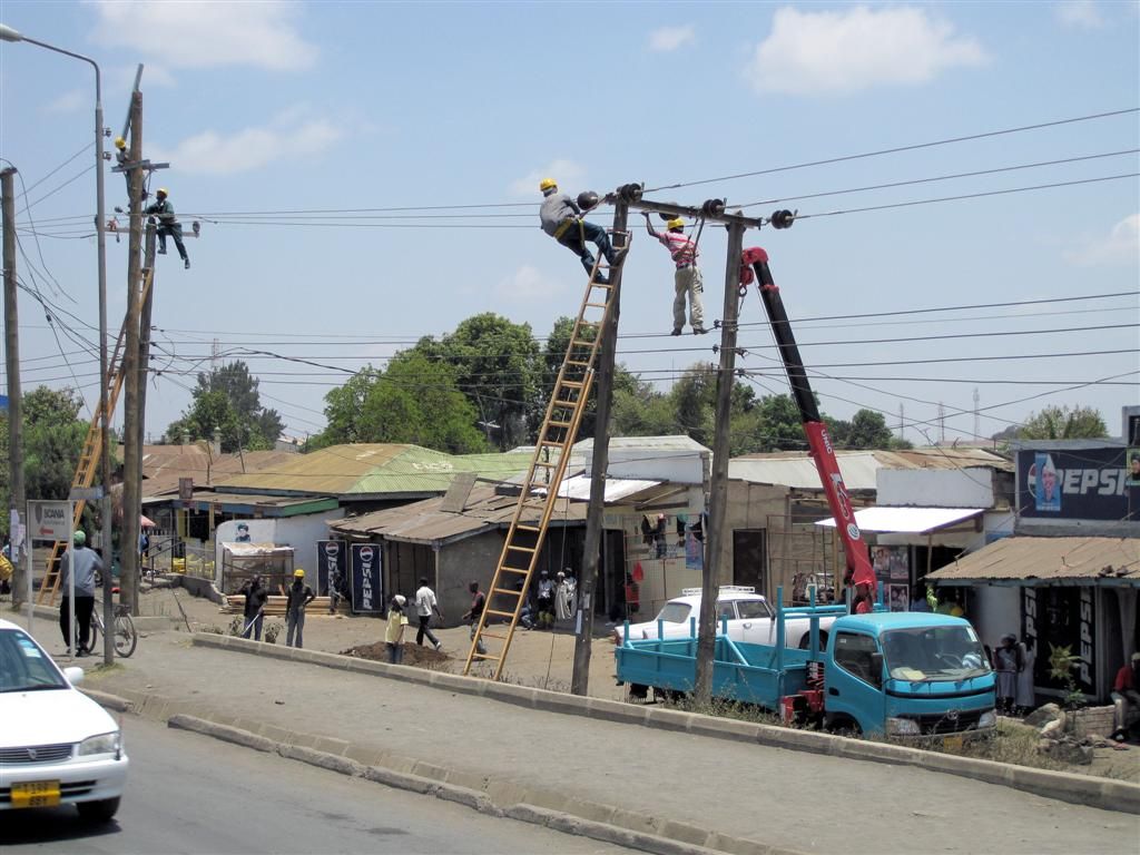 TANZANIA - ARUSHA - mannen aan het werk in elektriciteitspalen