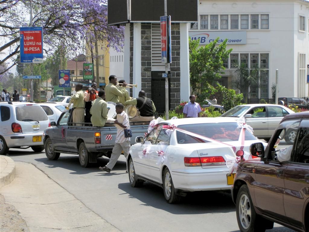 TANZANIA - ARUSHA - een bruidsauto begeleid door orkest