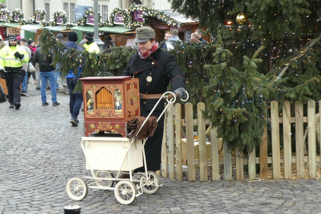 BRNO - een man met een draaiorgel op een kerstmarkt
