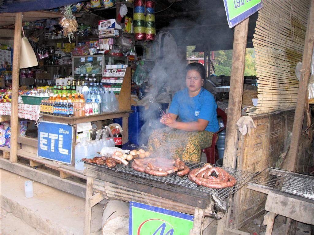 LAOS - PAK BENG - vrouw die vlees aan het barbequen is