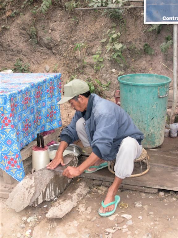 LAOS - PAK BENG - man is zijn mes aan het slijpen