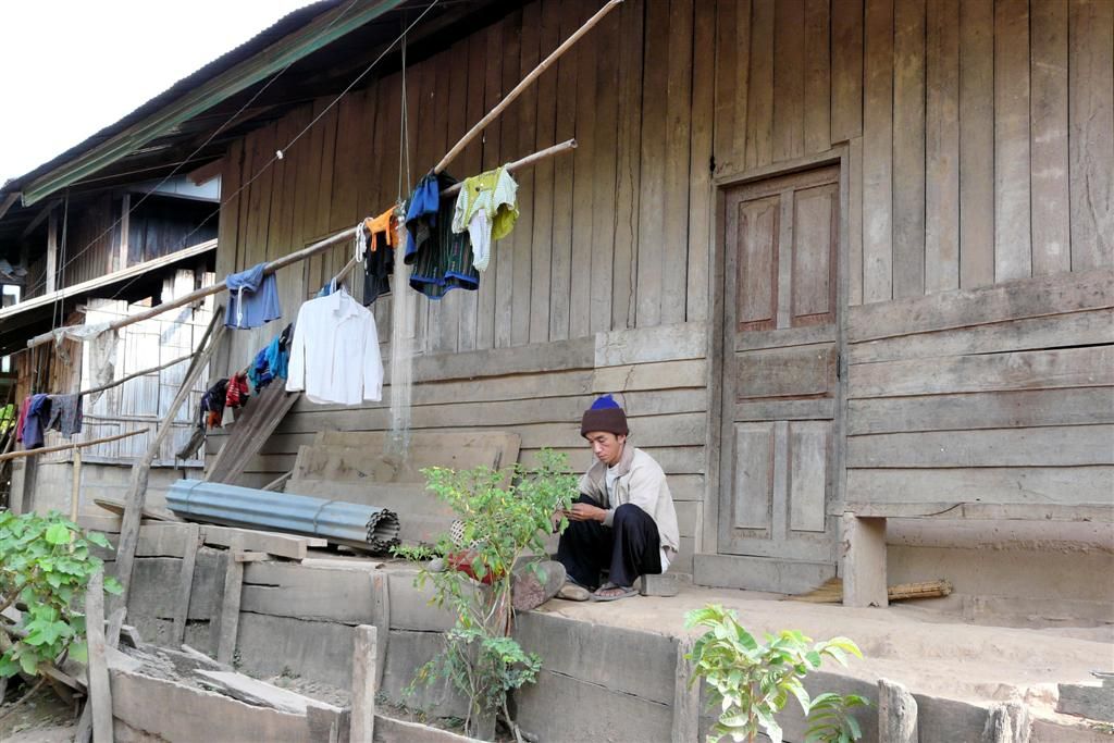 LAOS - PAK BENG -> LUANG PRABANG (stop bij een dorp) - man uit het dorp die zijn mes aan het slijpen is