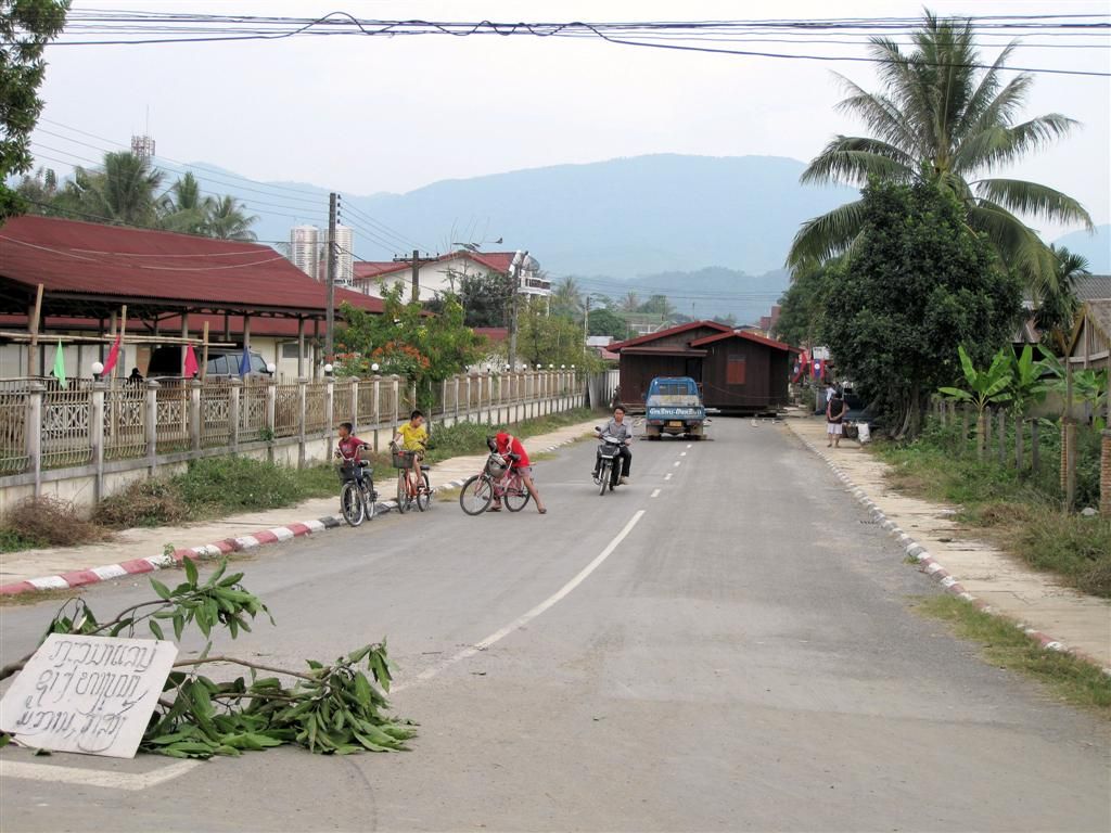 LAOS - VANG VIENG - een huis wordt over straat vervoerd