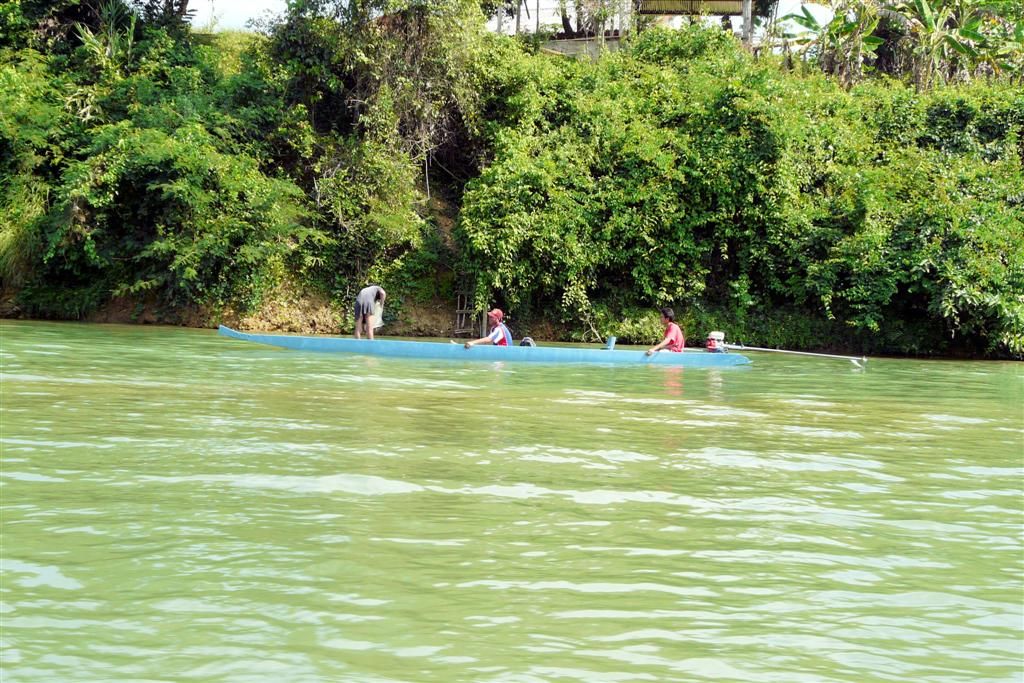 LAOS - VANG VIENG - lokale bevolking aan het varen over de Nam Song rivier