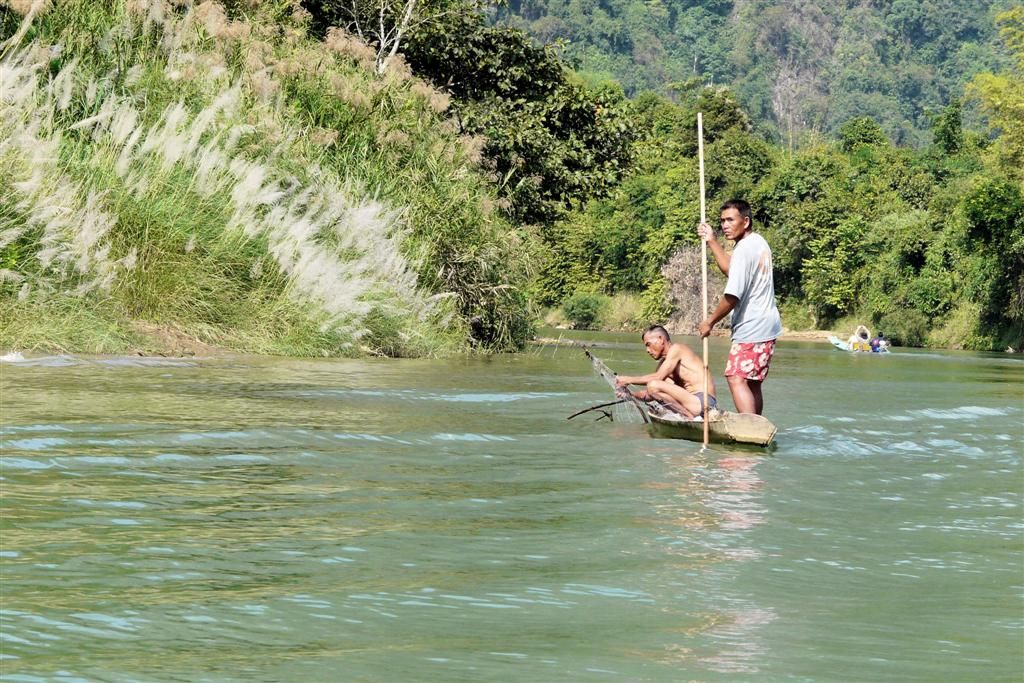 LAOS - VANG VIENG - twee vissers aan het vissen in de Nam Song rivier