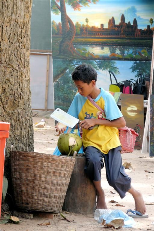 CAMBODJA - SIEM REAP - kind opent cocosnoot met hakmes