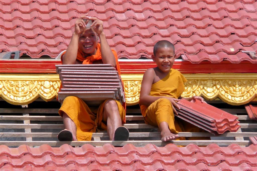 CAMBODJA - SIEM REAP - twee monniken op het dak in een dorpje