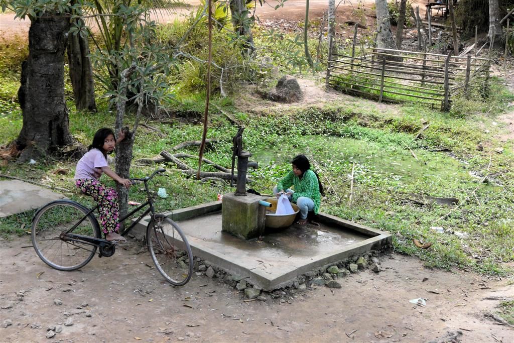 CAMBODJA - SIEM REAP - kind doet de was bij een handwaterpomp