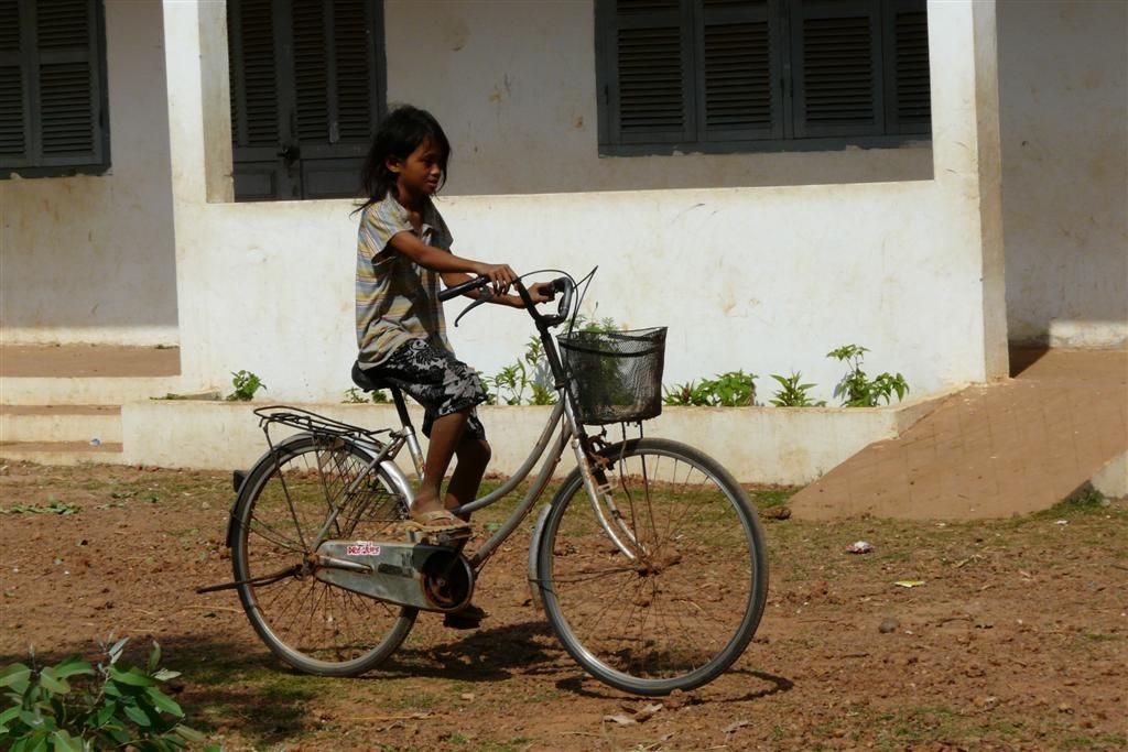 CAMBODJA - SIEM REAP - meisje op de fiets bij de school in het dorp Phum Chhuk