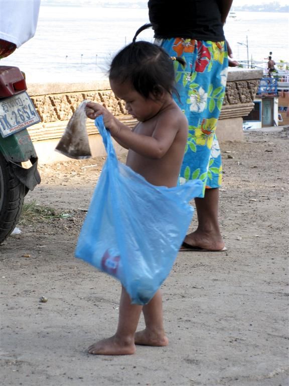 CAMBODJA - PHNOM PENH - kind aan het spelen met een plastic zak