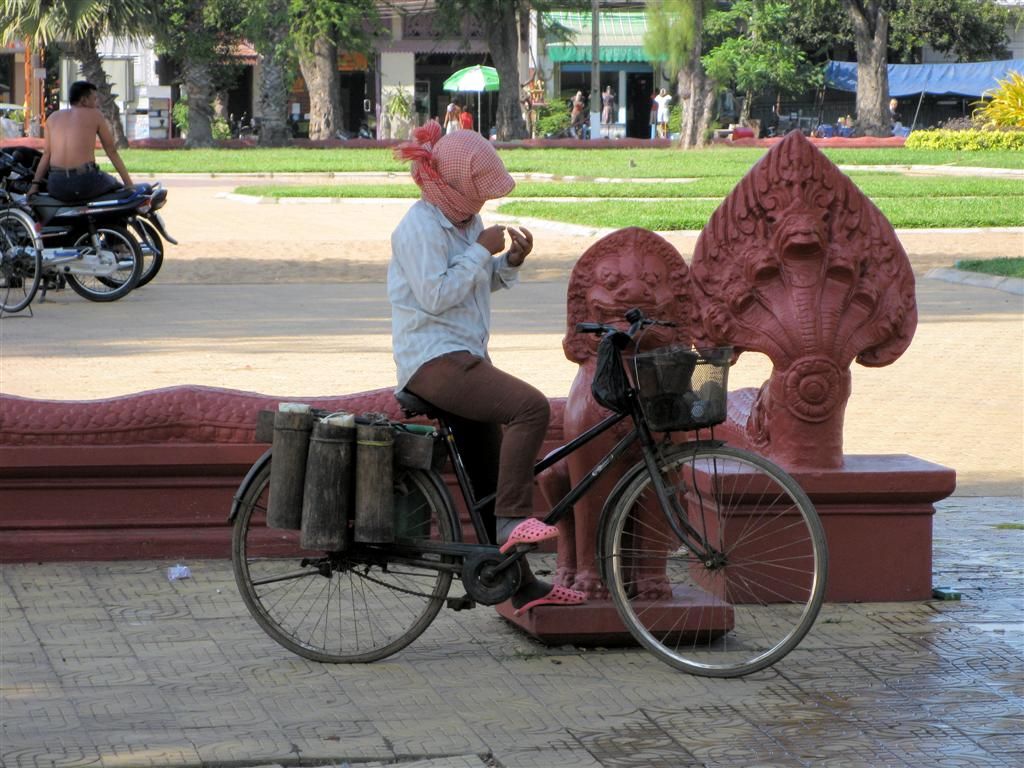 CAMBODJA - PHNOM PENH - kind met haar fiets draagt een hoofddoek