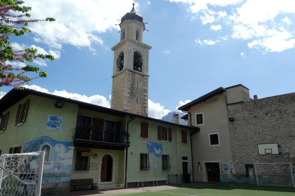 LIMONE SUL GARDA - een speelplaats en op de achtergrond de kerk van St. Benedictus