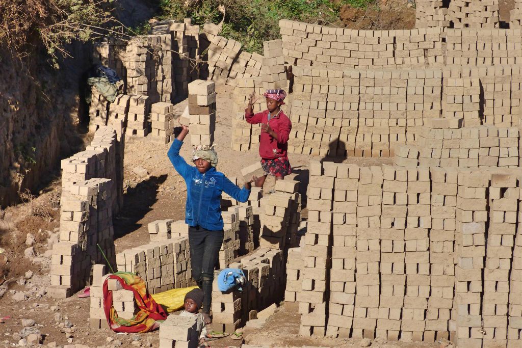 ANTANANARIVO - enkele Malagassiërs aan het werk in een bakstenen fabriekje