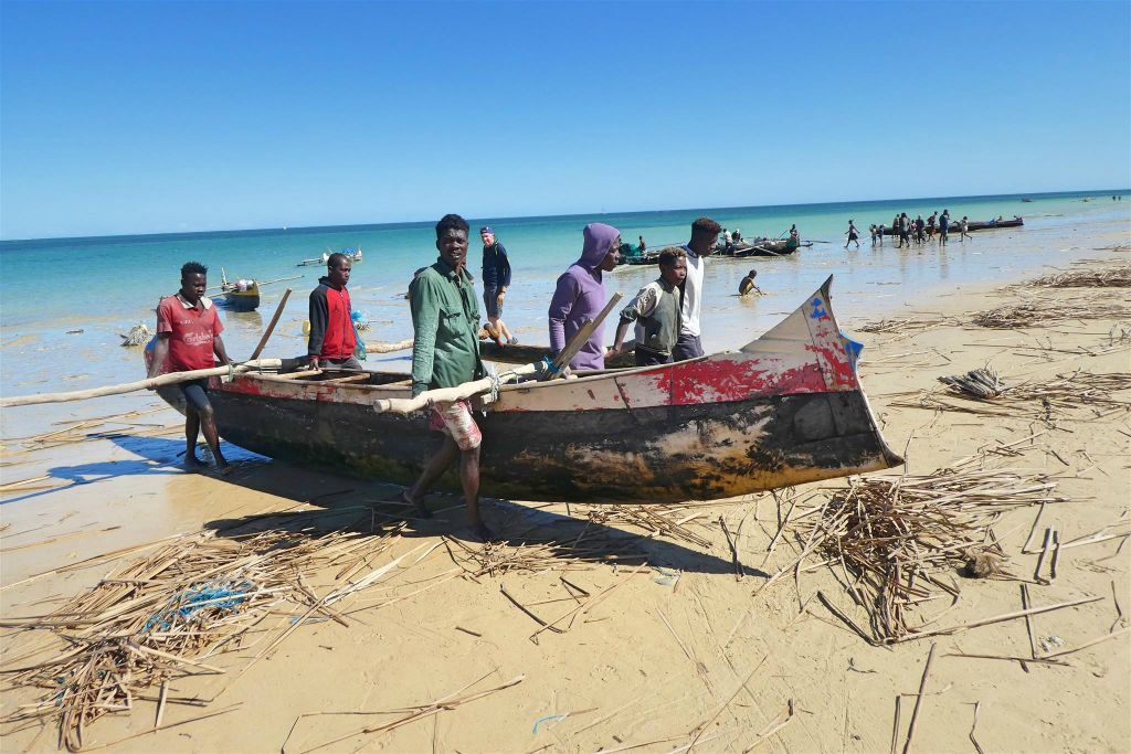IFATY - enkele Malagassiërs halen een boot uit het water