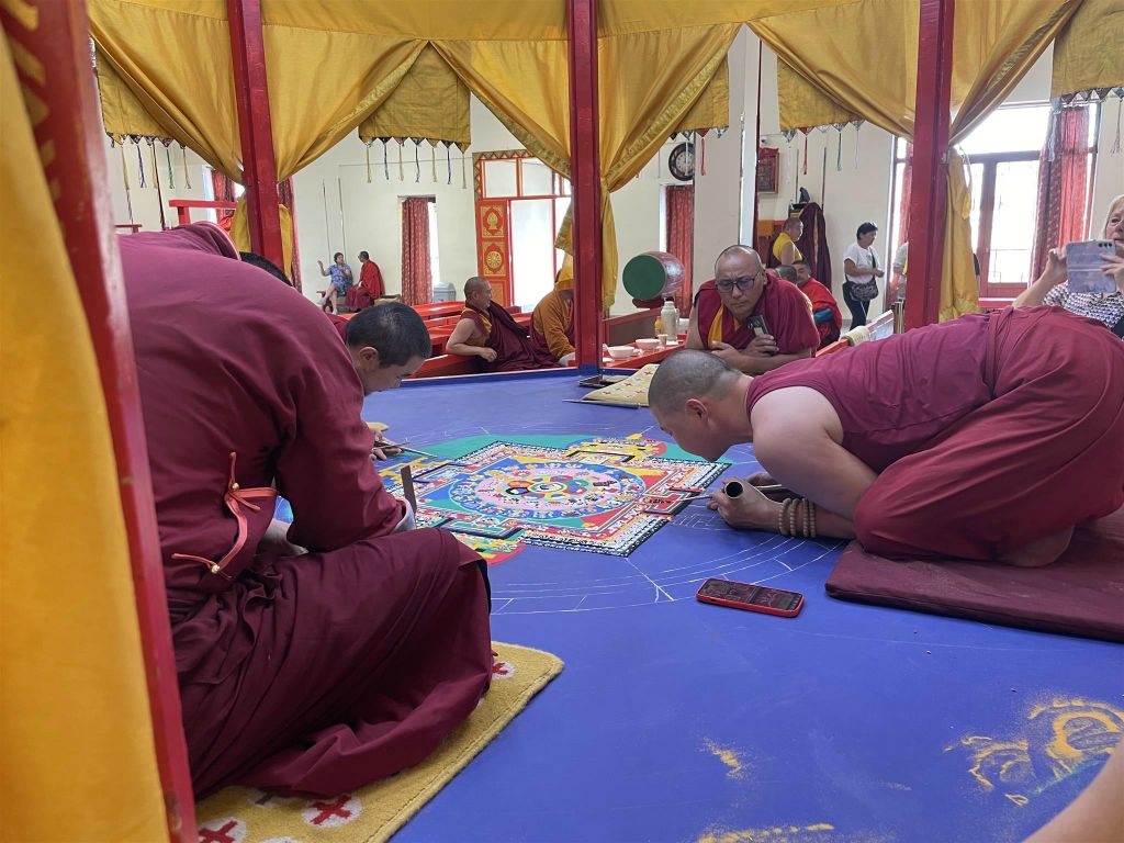 ULAANBAATAR - een aantal boeddhistische monniken die bezig zijn een mandala van gekleurd zand te maken in een kloostergebouw bij het Gandanklooster complex