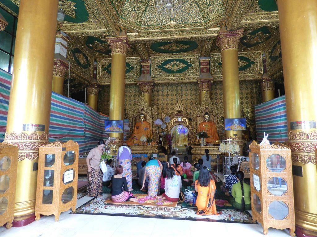 YANGON - enkele Myanmarezen aan het bidden op het complex van de Schwedagonpagode