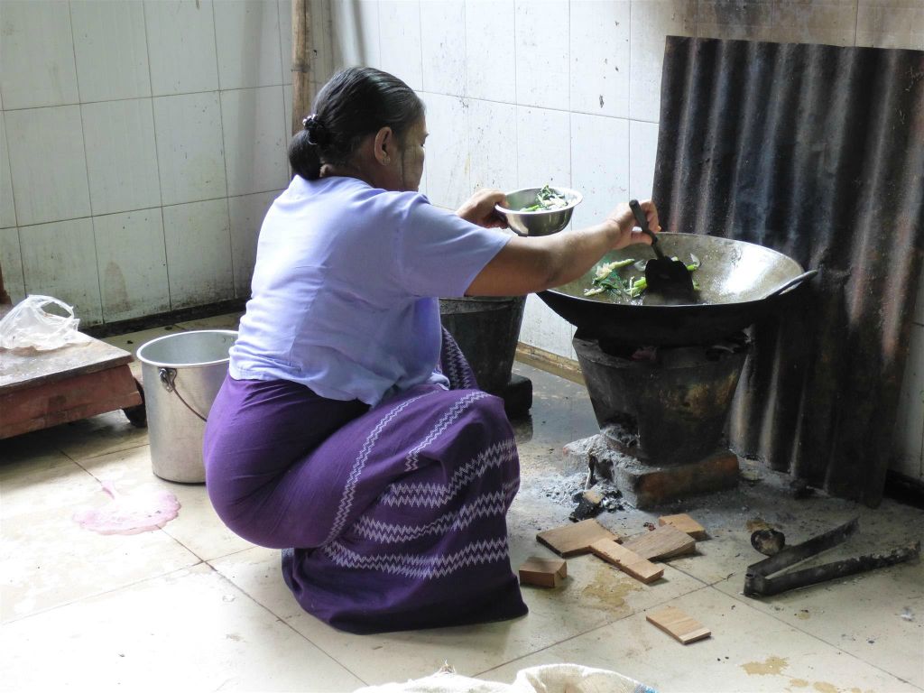 BAGO - een vrouw die aan het koken is in de keuken van het Kha Khat Wain Kyaung klooster